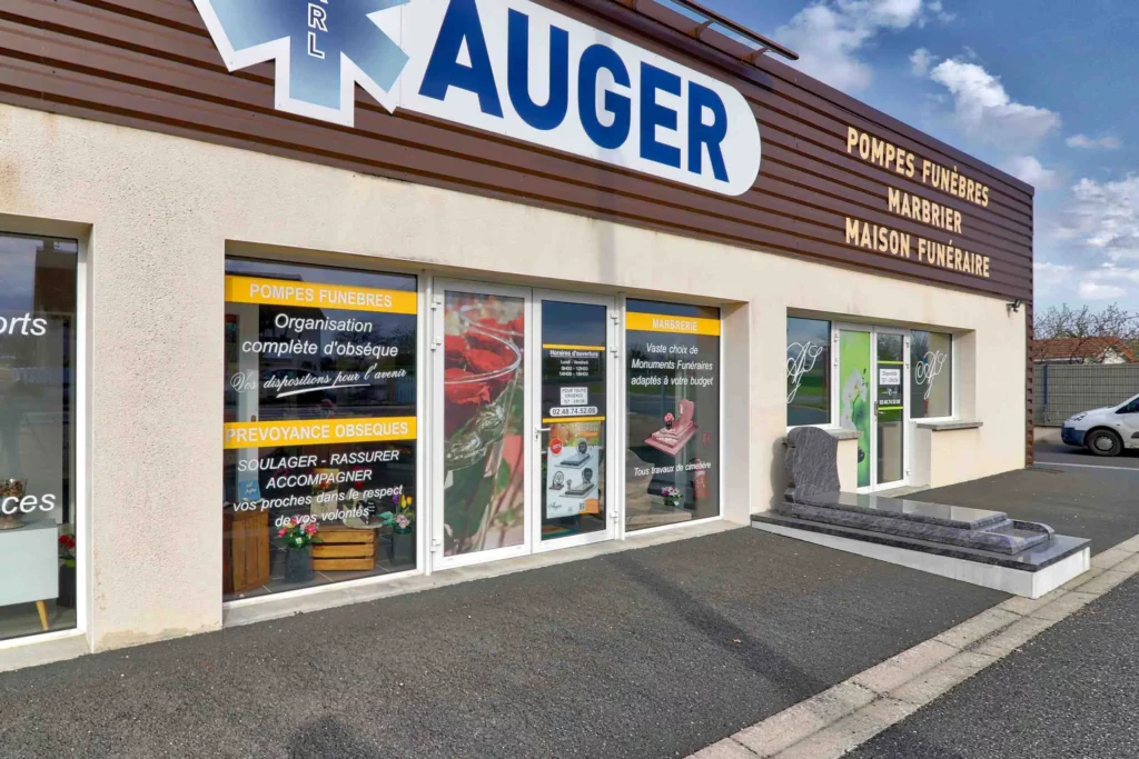 Vue extérieure du magasin Pompes Funèbres Auger avec vitrines d'information et monument funéraire